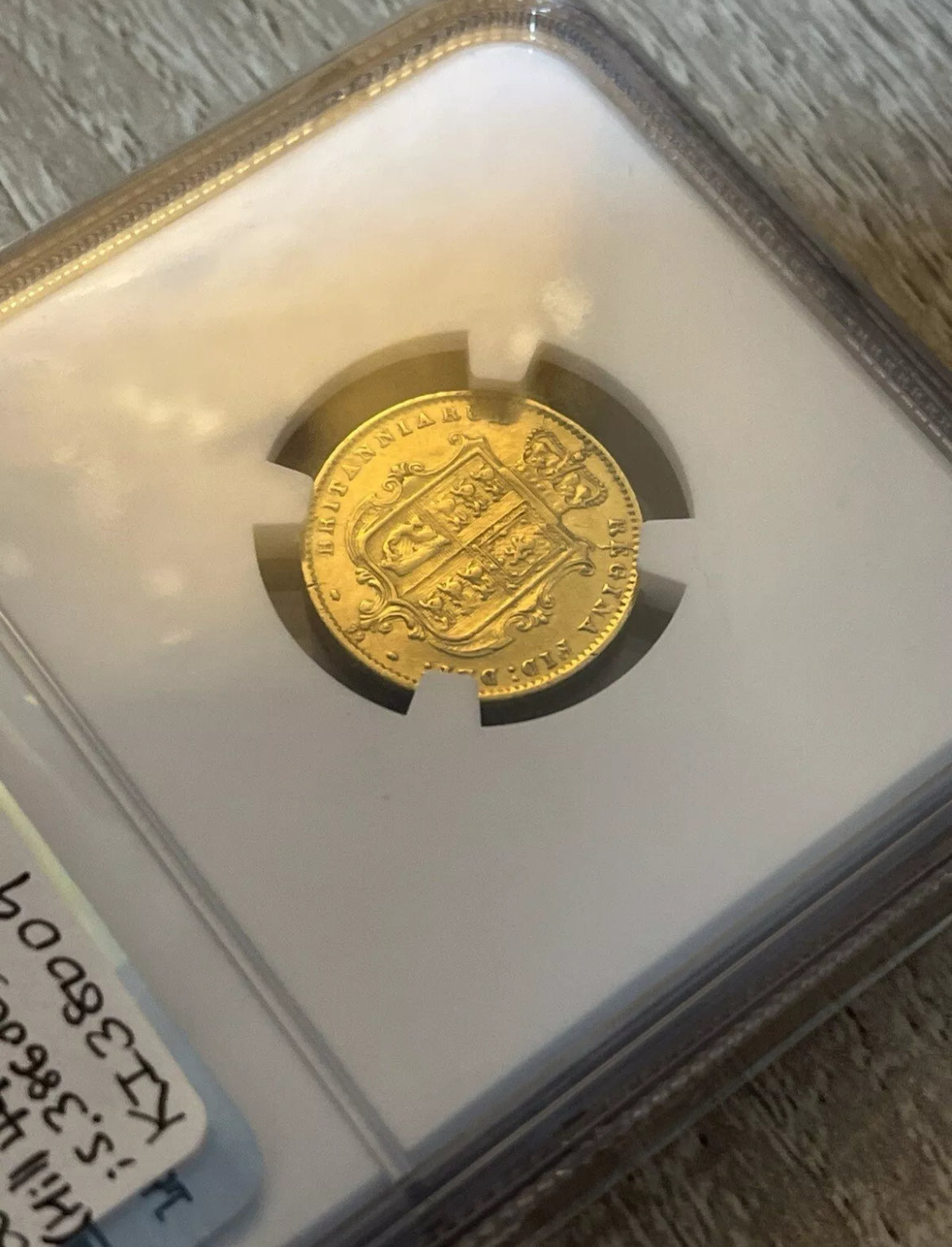 NGC graded gold sovereign with label showing coin grade and year